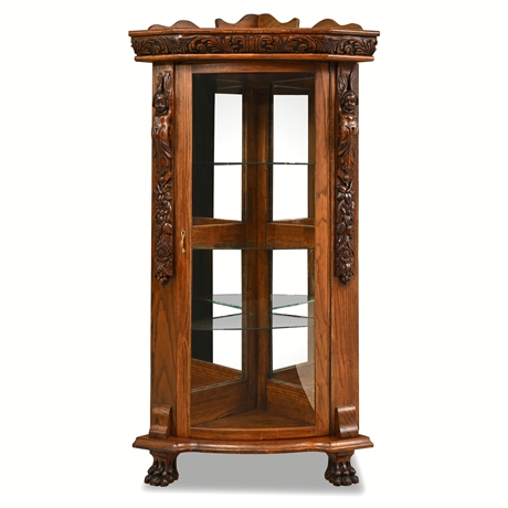 Oak Corner Curio Cabinet — Figural Carved Columns, Paw Feet, Glass Shelves